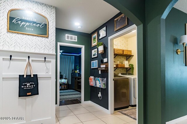 2756 Star Coral Ln, New Smyrna Beach, FL 32168 - interior space featuring washing machine and clothes dryer, arched walkways, light tile patterned floors, and baseboards