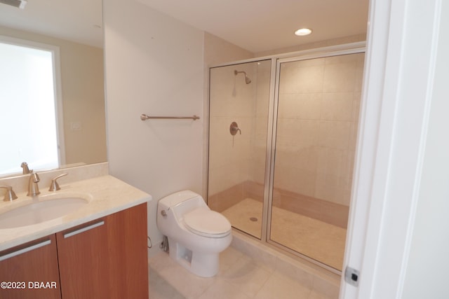 bathroom featuring toilet, vanity, tile patterned floors, and a shower with shower door