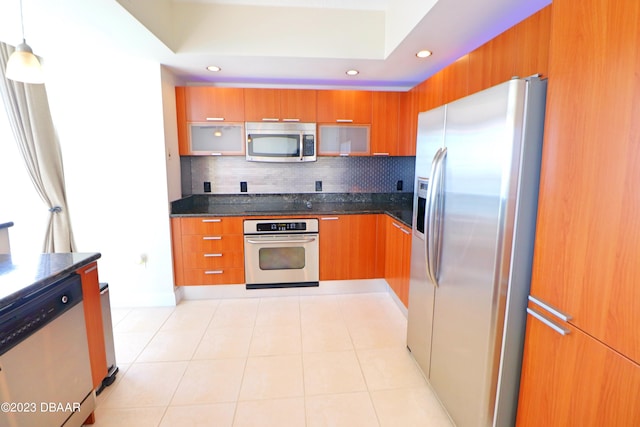 kitchen with stainless steel appliances, hanging light fixtures, light tile patterned flooring, and tasteful backsplash