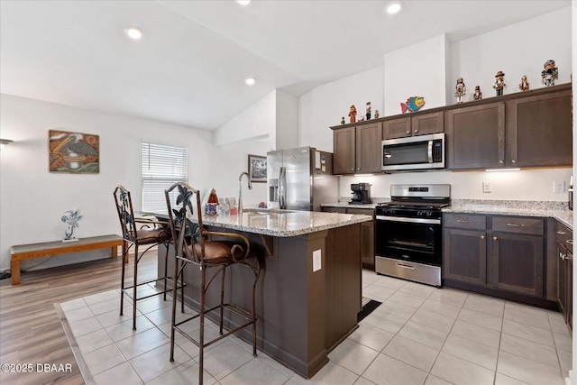 20 Willow St, Palm Coast, FL 32164 - kitchen with a kitchen bar, dark brown cabinets, a kitchen island with sink, a sink, and stainless steel appliances