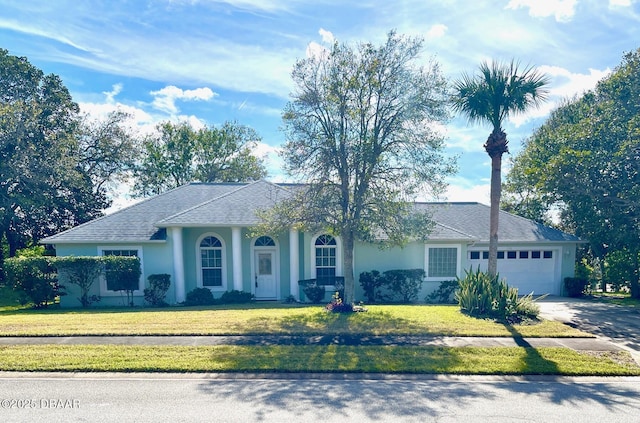 ranch-style house featuring a garage and a front lawn