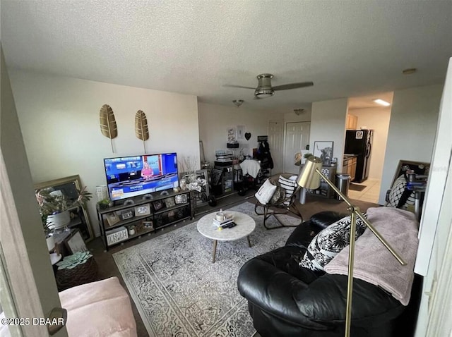 living room with a textured ceiling and ceiling fan