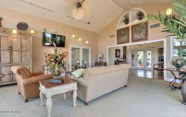 carpeted living room with high vaulted ceiling, beam ceiling, french doors, and rail lighting