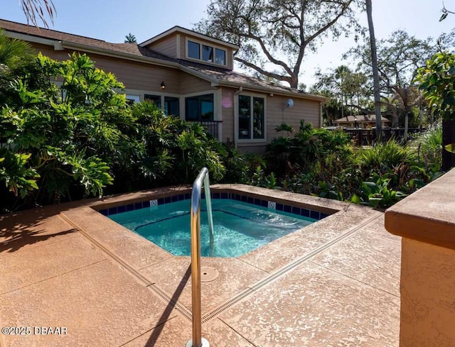 view of pool featuring an in ground hot tub