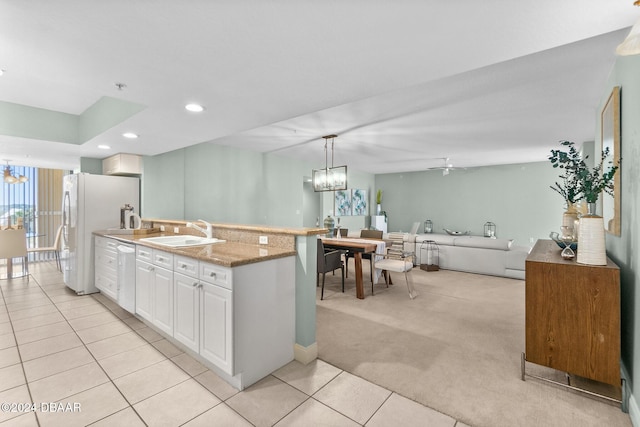 kitchen with sink, stainless steel dishwasher, pendant lighting, light carpet, and white cabinets