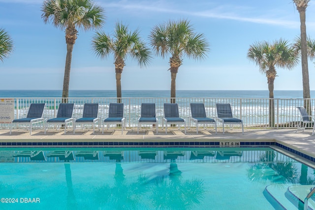 view of pool with a patio area and a water view