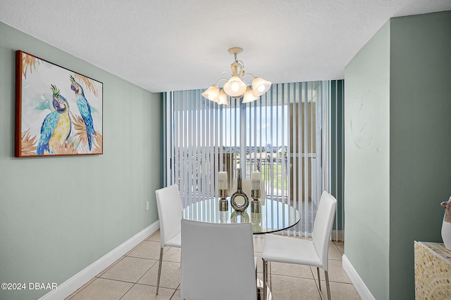 tiled dining space featuring a chandelier and a textured ceiling