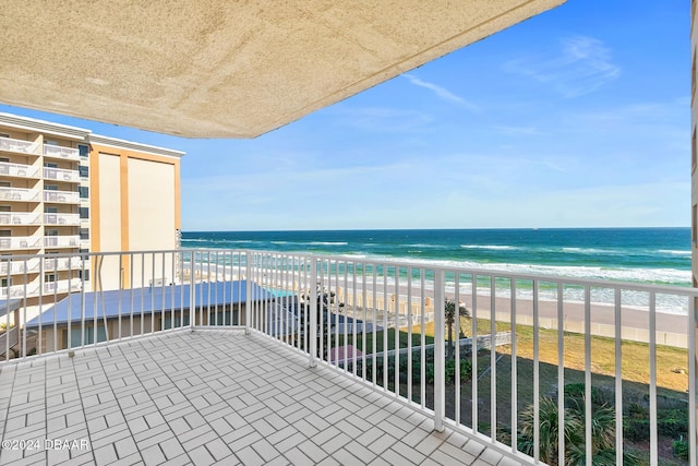 balcony featuring a beach view and a water view