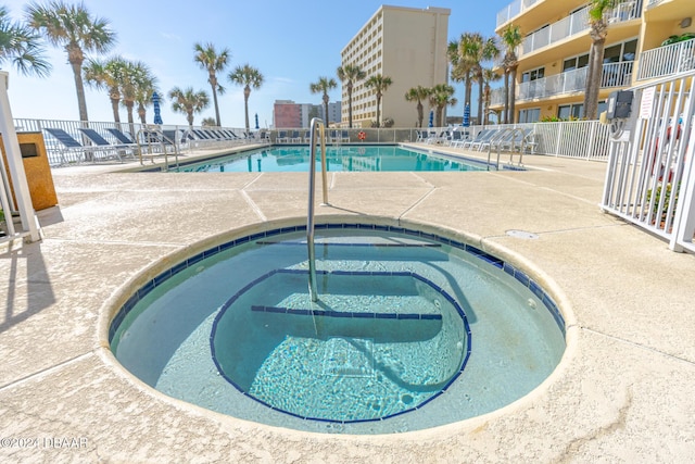 view of swimming pool featuring a hot tub