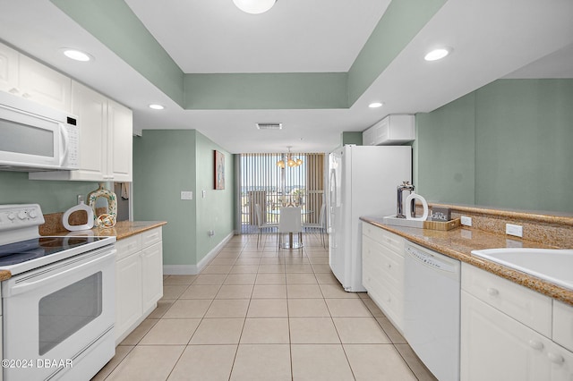 kitchen with white cabinets, light tile patterned floors, white appliances, and a chandelier