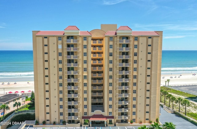 view of building exterior with a view of the beach and a water view