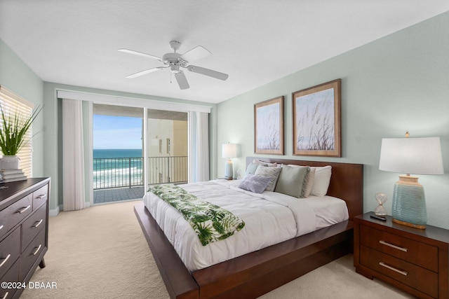 bedroom featuring access to exterior, ceiling fan, a water view, and light carpet