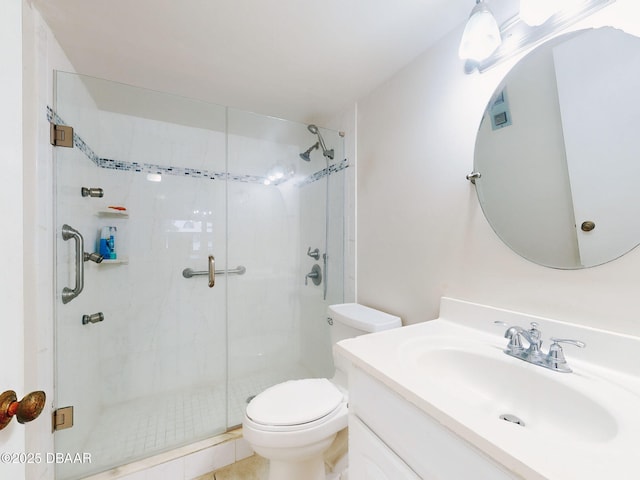 bathroom featuring tile patterned flooring, vanity, a shower with shower door, and toilet