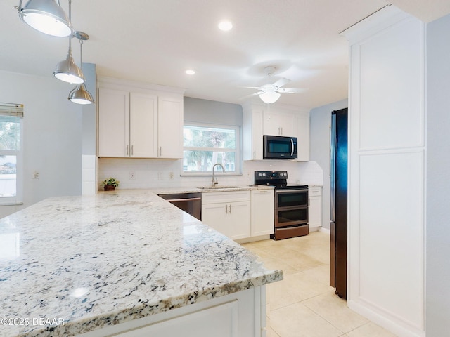 kitchen featuring tasteful backsplash, white cabinetry, sink, hanging light fixtures, and stainless steel appliances