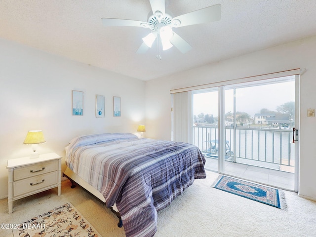 carpeted bedroom with access to outside, a textured ceiling, and ceiling fan