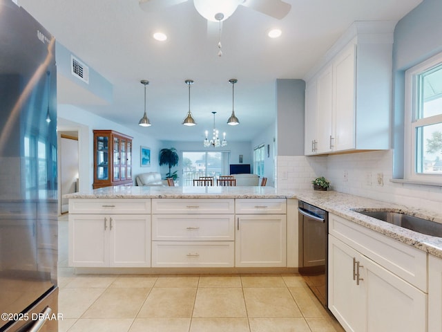 kitchen with decorative light fixtures, kitchen peninsula, stainless steel appliances, decorative backsplash, and white cabinets