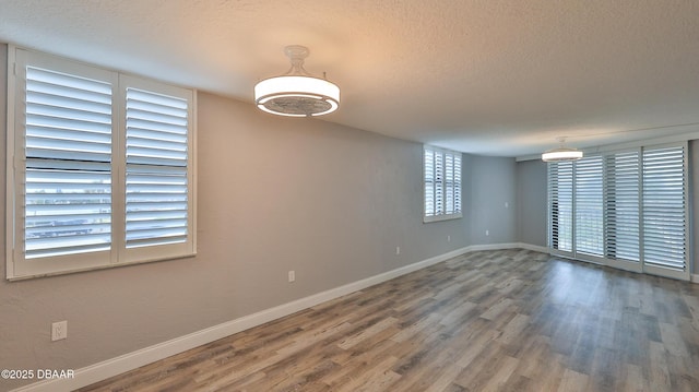 empty room featuring wood-type flooring and a textured ceiling