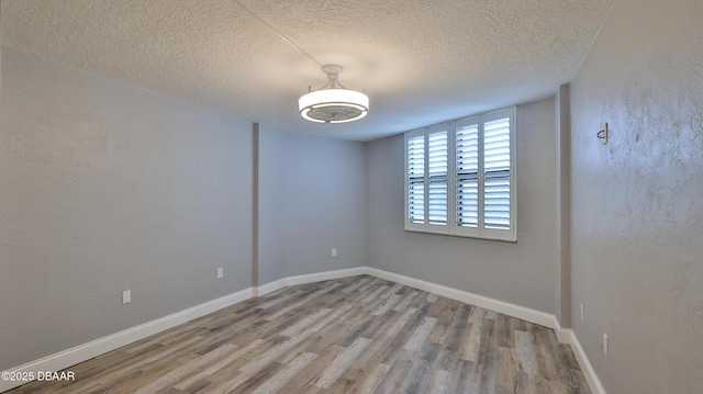 empty room featuring light hardwood / wood-style floors and a textured ceiling