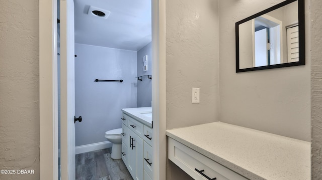 bathroom with hardwood / wood-style flooring, vanity, and toilet