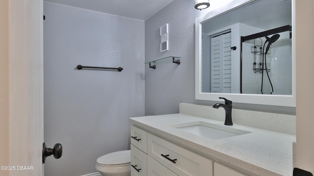 bathroom featuring vanity, walk in shower, and toilet