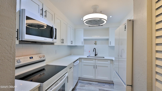 kitchen with white cabinetry, white appliances, sink, and decorative backsplash