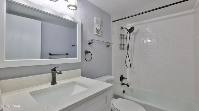 full bathroom featuring tiled shower / bath, vanity, and toilet