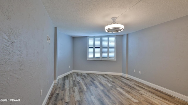 empty room featuring a textured ceiling and light wood-type flooring