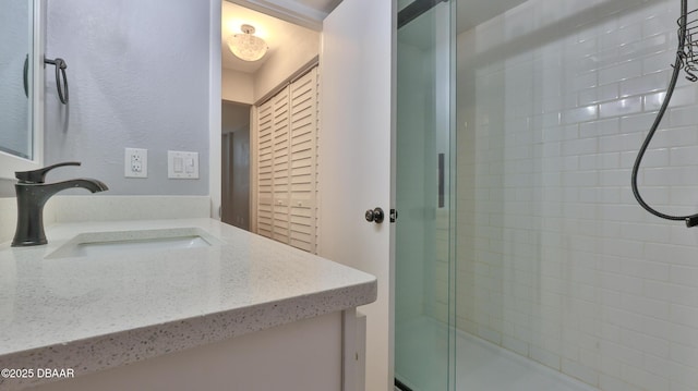 bathroom with vanity and a shower with shower door