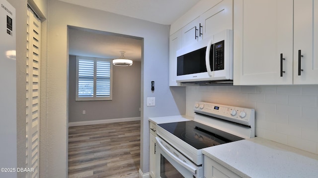 kitchen featuring white cabinetry, light stone counters, white appliances, and tasteful backsplash