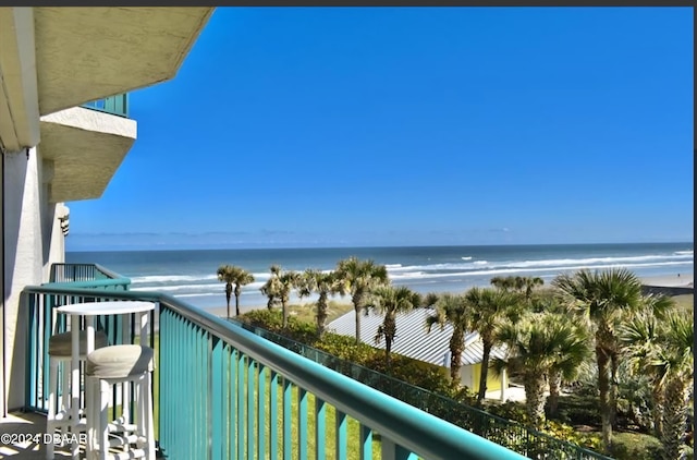 balcony featuring a view of the beach and a water view