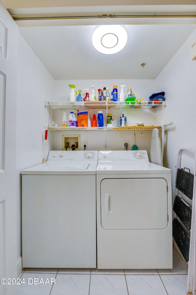 laundry area with washing machine and clothes dryer and light tile patterned flooring