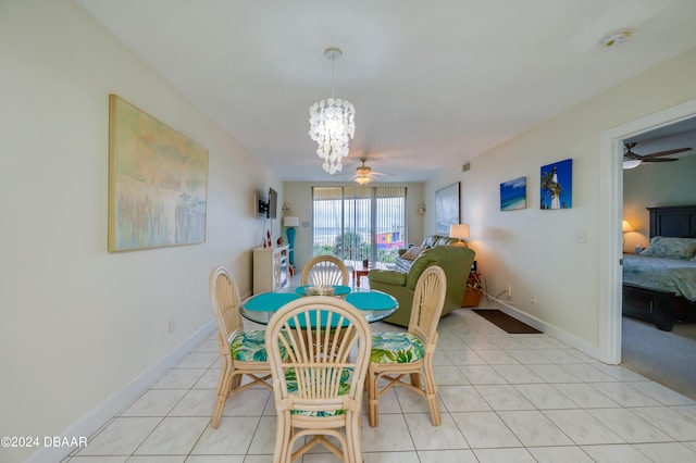 dining space featuring light tile patterned flooring and ceiling fan with notable chandelier