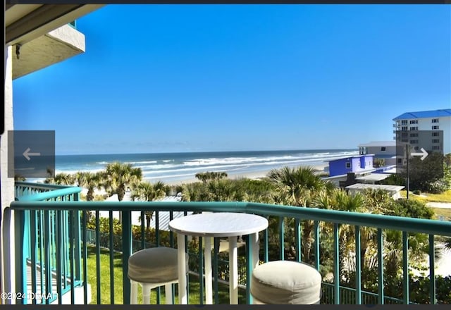 balcony featuring a beach view and a water view