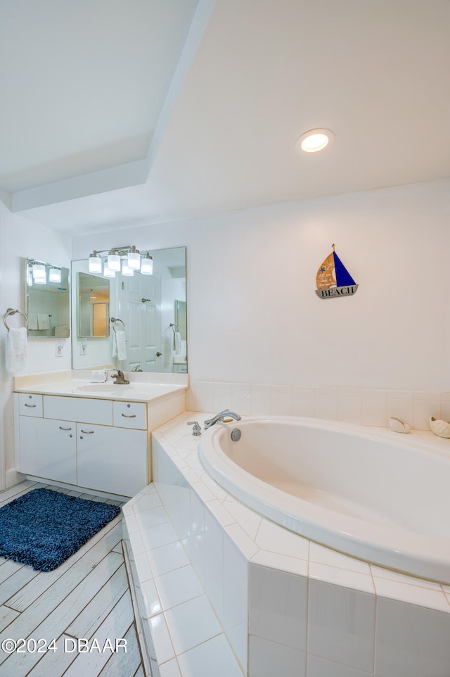 bathroom with vanity and a relaxing tiled tub