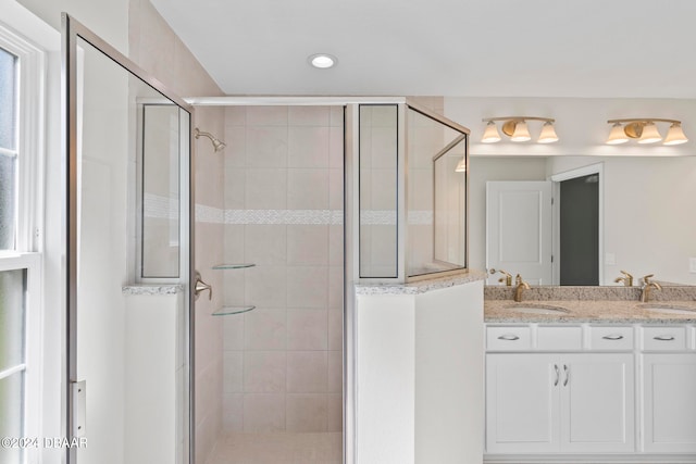 bathroom with a shower with shower door and vanity