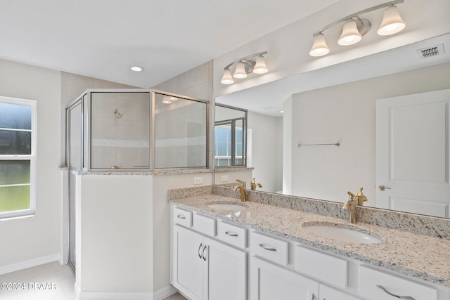 bathroom with walk in shower, vanity, and tile patterned floors