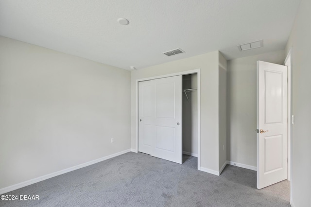 unfurnished bedroom featuring carpet flooring and a closet