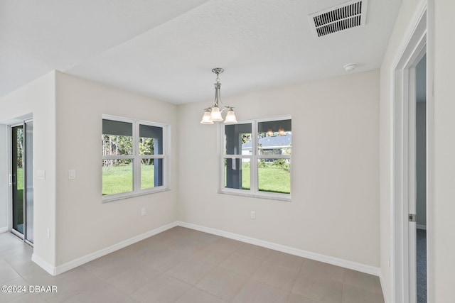 spare room featuring a chandelier