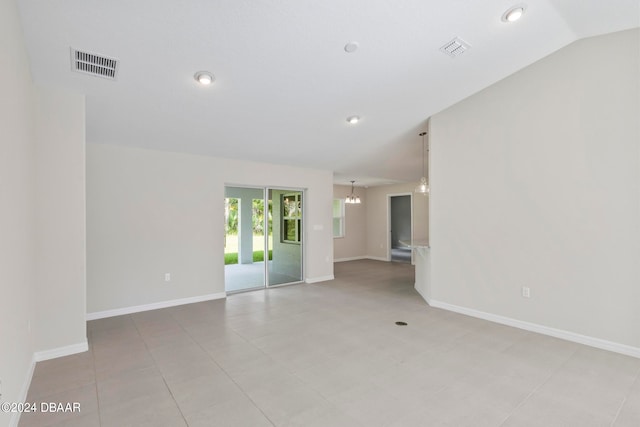 tiled empty room with a chandelier and lofted ceiling