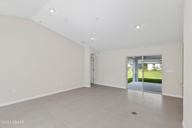 unfurnished room featuring lofted ceiling and light tile patterned floors