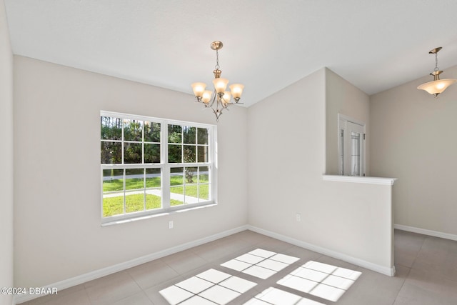 tiled empty room featuring an inviting chandelier