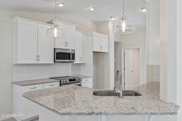 kitchen featuring appliances with stainless steel finishes, decorative light fixtures, and white cabinets