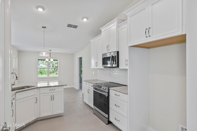 kitchen with stainless steel appliances, light stone countertops, white cabinetry, and sink