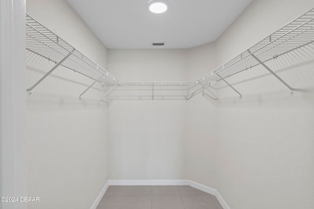 walk in closet with tile patterned floors