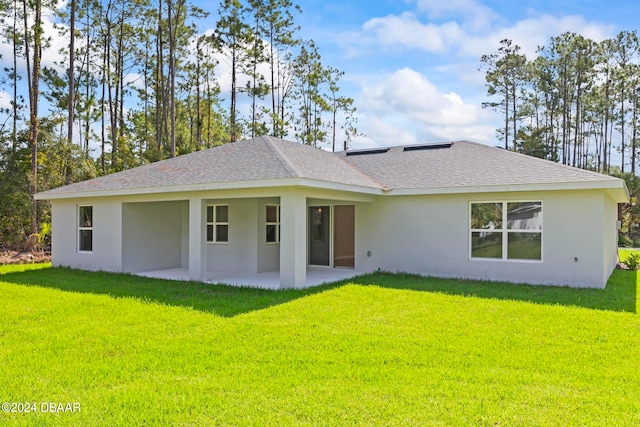 rear view of house featuring a patio and a yard