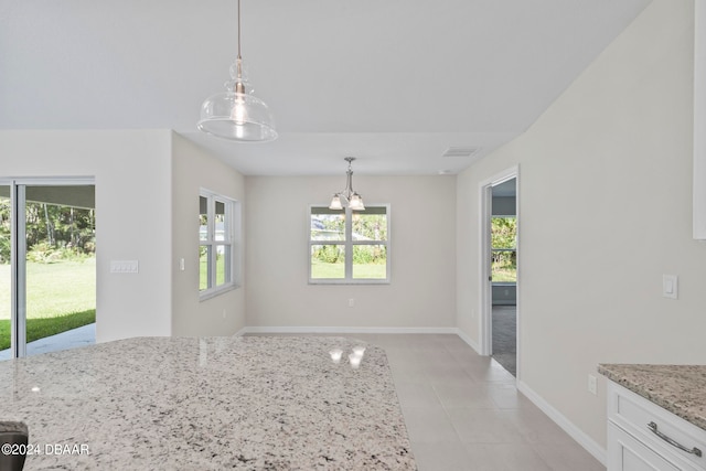 unfurnished dining area featuring a chandelier and light tile patterned flooring