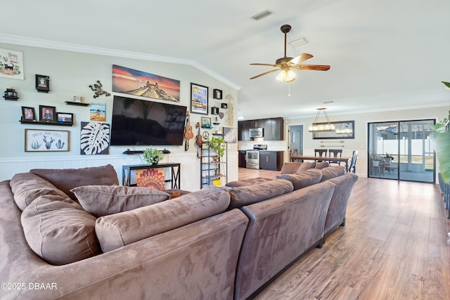 living room featuring light wood-type flooring, ornamental molding, lofted ceiling, and ceiling fan