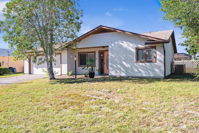 ranch-style house featuring a garage and a front lawn