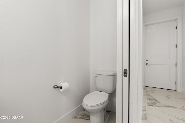 bathroom featuring toilet, baseboards, and marble finish floor