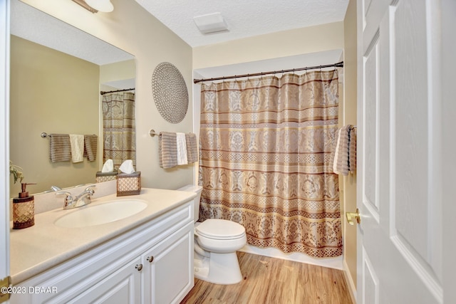 4670 Links Village Dr Unit B102, Ponce Inlet, FL 32127 - full bath with vanity, toilet, wood finished floors, a shower with curtain, and a textured ceiling